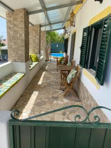 a balcony of a house with chairs and a patio at Casa dos avós in São Brás de Alportel