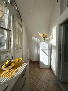 a kitchen with a white refrigerator and a bowl of bananas at Casa Maria Rosa - seaside apartment in Sorrento +17 photos