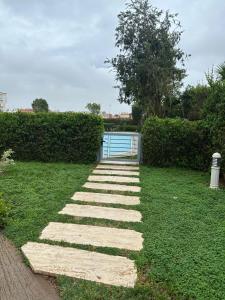 a stepping stone pathway in a yard with a gate at Luxury Apartment with swimming pool in El Jadida