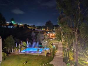 a fountain in the middle of a park at night at Hotel Mansion Sant Serrant Medellín- Aeropuerto Rionegro in Marinilla