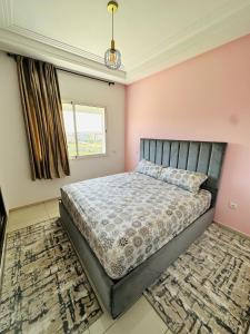a bedroom with a bed and a window at Luxury Apartment with swimming pool in El Jadida