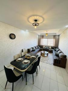 a living room with a table and a couch at Luxury Apartment with swimming pool in El Jadida