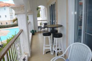 un balcone con tavolo e sgabelli accanto alla piscina di Cadaques Caribe Boulevard Dominicus Americanus Carretera a Bayahibe Vel 206 a Bayahibe
