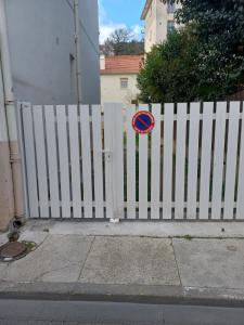 a white picket fence with a sign on it at Centre ville d'Amelie les bains in Amélie-les-Bains-Palalda