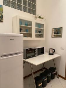 a kitchen with a table with a microwave and a refrigerator at Civico 8 in Prato