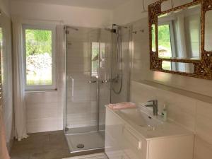 a white bathroom with a shower and a sink at Landhuus Stender in Eutin