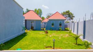 a yard with two houses and a fence at Nyitika Hotel in Mugumu