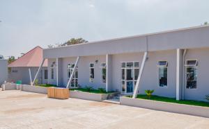 a large white building with a lot of windows at Nyitika Hotel in Mugumu