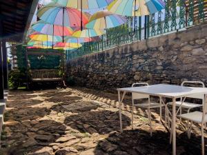 a table and chairs with umbrellas hanging from a fence at Casa de Veraneio Villa Lopes in Bonfim
