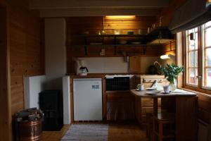cocina con nevera blanca y mesa en Åkviktunet hytte Sør, en Averoy