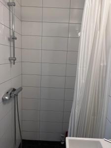 a bathroom with a shower curtain and a sink at Rådhus in Bara