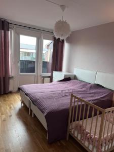 - une chambre avec un lit doté d'une couette violette et d'une fenêtre dans l'établissement Rådhus, à Bara