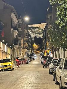 une rue de la ville la nuit avec des voitures garées dans l'établissement Cute studio near acropolis, à Athènes
