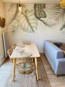 een tafel en stoelen in een woonkamer met een bank bij appartement paradise tropical in Juvignac