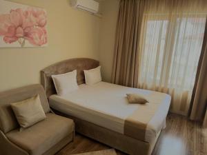 a bed and a chair in a room at Hotel Silver in Sozopol