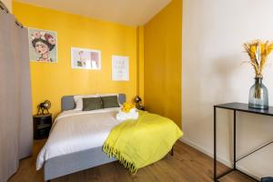 a bedroom with a bed with a yellow wall at Confort moderne à Marseille in Marseille