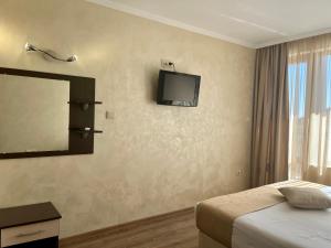 a bedroom with a bed and a television on the wall at Hotel Silver in Sozopol