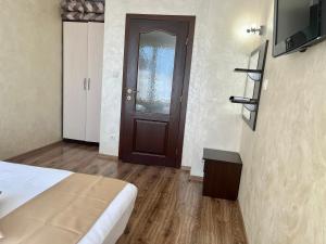 a room with a bed and a door and a television at Hotel Silver in Sozopol