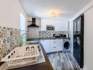 a kitchen with a sink and a dishwasher at Forest side cottage in Nottingham