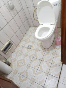 a bathroom with a toilet and a tiled floor at RESIDENCE WALNICK in Douala
