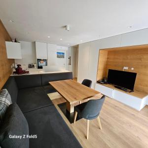 sala de estar con mesa de madera y cocina en Sonnenparadies, en San Genesio Atesino