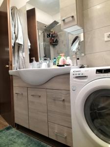 une salle de bain avec un lavabo et une machine à laver dans l'établissement 250 m dalla spiaggia! Spiaggia libera o attrezzata - LA CASA DI KATE, à Grado