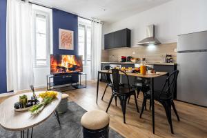 a kitchen and living room with a dining table and a fireplace at Confort moderne à Marseille in Marseille