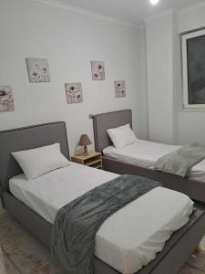 sypialnia z 2 łóżkami i stołem z lampką w obiekcie Sun and Salt Villas w mieście Poros