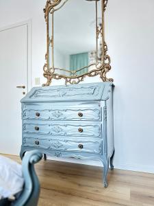 a blue dresser with a mirror on top of it at Casa di Maya in Portacomaro