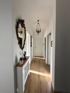 a hallway with white walls and a mirror on the wall at Casa di Maya in Portacomaro