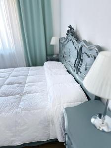 sypialnia z łóżkiem i lampką na stole w obiekcie Casa di Maya w mieście Portacomaro