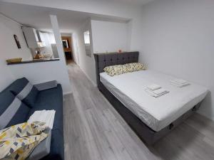 um quarto com uma cama grande e um sofá em Apartman Amfora em Malinska