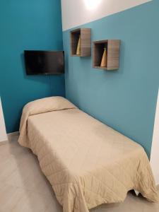 a bedroom with a bed and a blue wall at Kristal in Cinisi