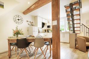 eine Küche und ein Esszimmer mit einem Holztisch und Stühlen in der Unterkunft BREDALA**** Gîte maison Alsacienne avec Jardin in Eguisheim