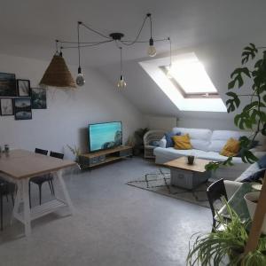 sala de estar con sofá y TV en Expérience Cocooning typé Loft en Braux