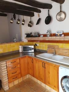 cocina con fregadero y microondas en Private pool in Lecrin 30 min Granada/beach, en Albuñuelas