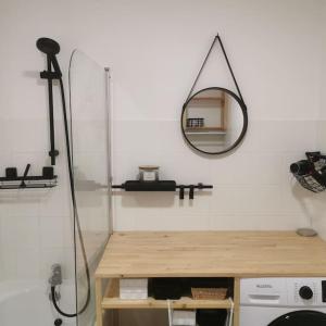 baño con espejo, mesa y lavamanos en Expérience Cocooning typé Loft en Braux