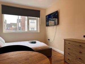 a bedroom with a bed and a window at High-End Central Luton Studio - Ideal for Airport! in Luton