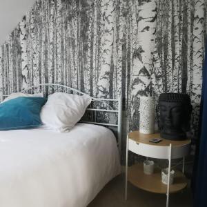 - une chambre avec un lit et du papier peint noir et blanc dans l'établissement Expérience Cocooning typé Loft, à Braux