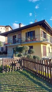 een huis met een houten hek ervoor bij Al Vecchio Lavatoio in Colle Brianza
