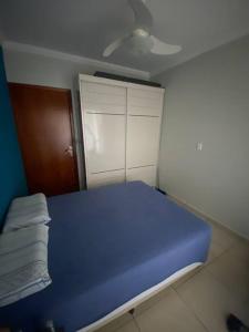 um quarto com uma cama azul e um armário branco em Área aconchegante com piscina em Londrina