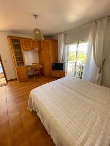 Schlafzimmer mit einem weißen Bett und einem TV in der Unterkunft Villa U Mulinu in Calvi