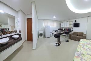 a bathroom with two sinks and a room with a couch at 8-Flat confortável lugar nobre in Manaus