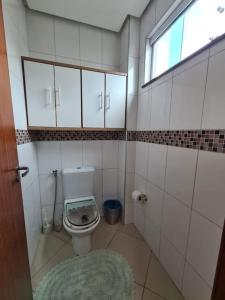 a small bathroom with a toilet and a window at 8-Flat confortável lugar nobre in Manaus +7 photos