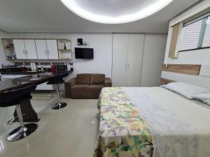 a bedroom with a bed and a desk and a kitchen at 8-Flat confortável lugar nobre in Manaus