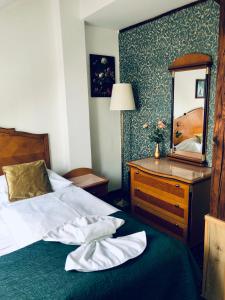 a bedroom with a bed and a dresser and a mirror at Hotel GEO in Prague