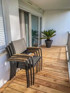 Un balcón con 2 sillas, una mesa y una planta en T3 Moderne avec balcon terrasse et parking gratuit, en Niort