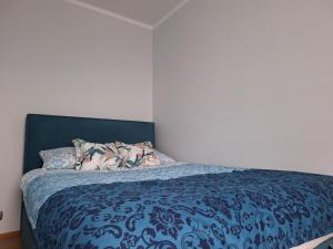 sypialnia z łóżkiem z niebieską kołdrą w obiekcie Turkusowa Apartament w Szczecinie