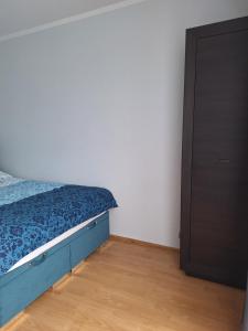a bedroom with a blue bed and a closet at Turkusowa Apartament in Szczecin