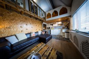 City Style Lofts في شيفيلد: غرفة معيشة مع أريكة جلدية وطاولة